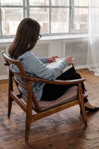 Photo by cottonbro studio: https://www.pexels.com/photo/woman-in-white-long-sleeve-shirt-sitting-on-brown-wooden-chair-4101147/